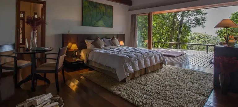 Quarto da Morada Bosque do Kuriuwa, em dois andares, com cama ampla e deck aberto sobre a floresta