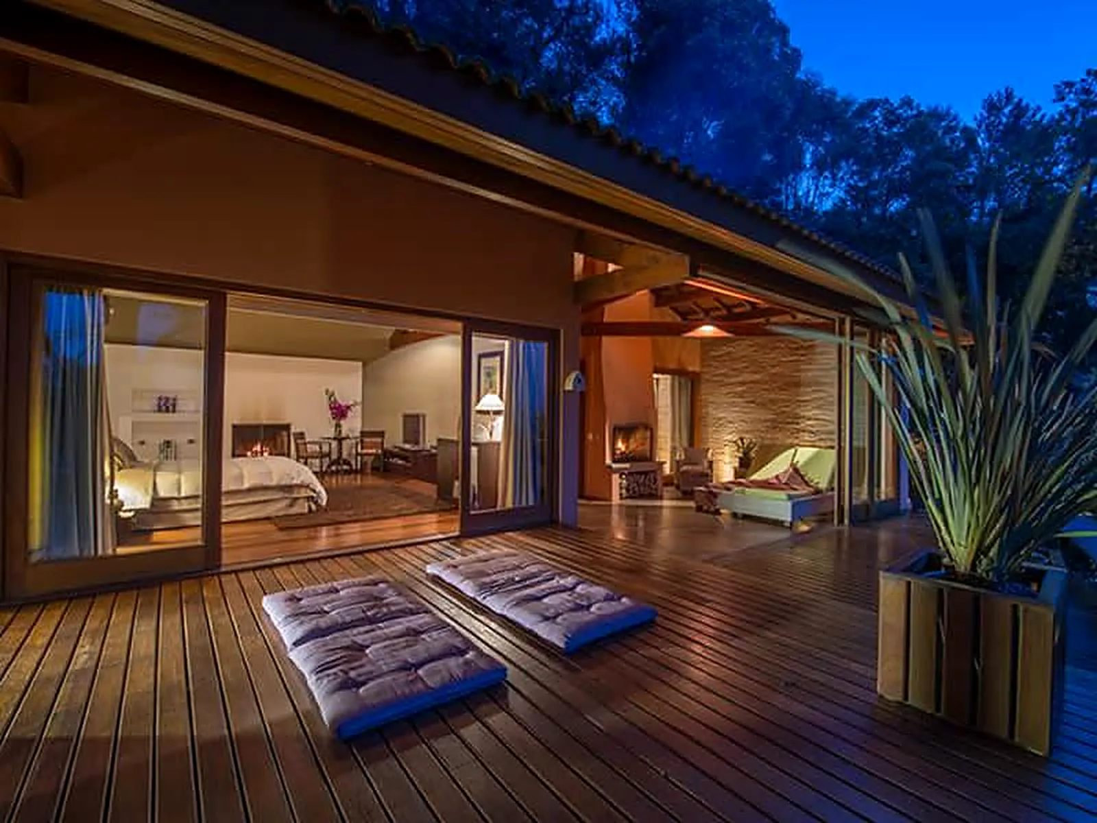 Deck de uma morada do Kuriuwa Hotel na hora azul, entre as araucárias da Serra da Mantiqueira